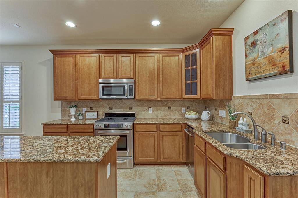 Island kitchen features gas range, granite counters, and abundant cabinet space.