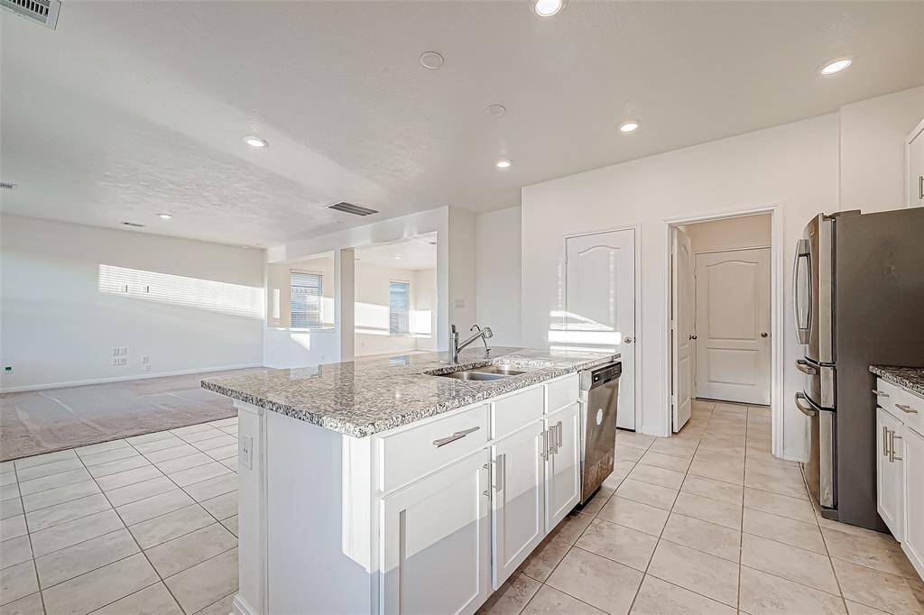 The kitchen is separated from the family room and breakfast area by an extended breakfast bar. This is a great spot to grab a quick meal, serve snacks and drinks to guests, or add bar stools to create additional seating.