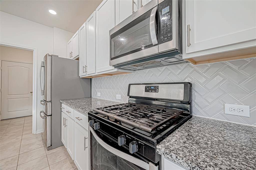 Bring the heat with the stainless steel range, perfectly paired with a built-in microwave for quick meals and multitasking ease. Cleanup is a breeze thanks to the sleek stainless dishwasher, all surrounded by granite countertops and chic herringbone backsplash. With everything you need right where you want it, this kitchen is prepped for everyday cooking and weekend hosting alike.