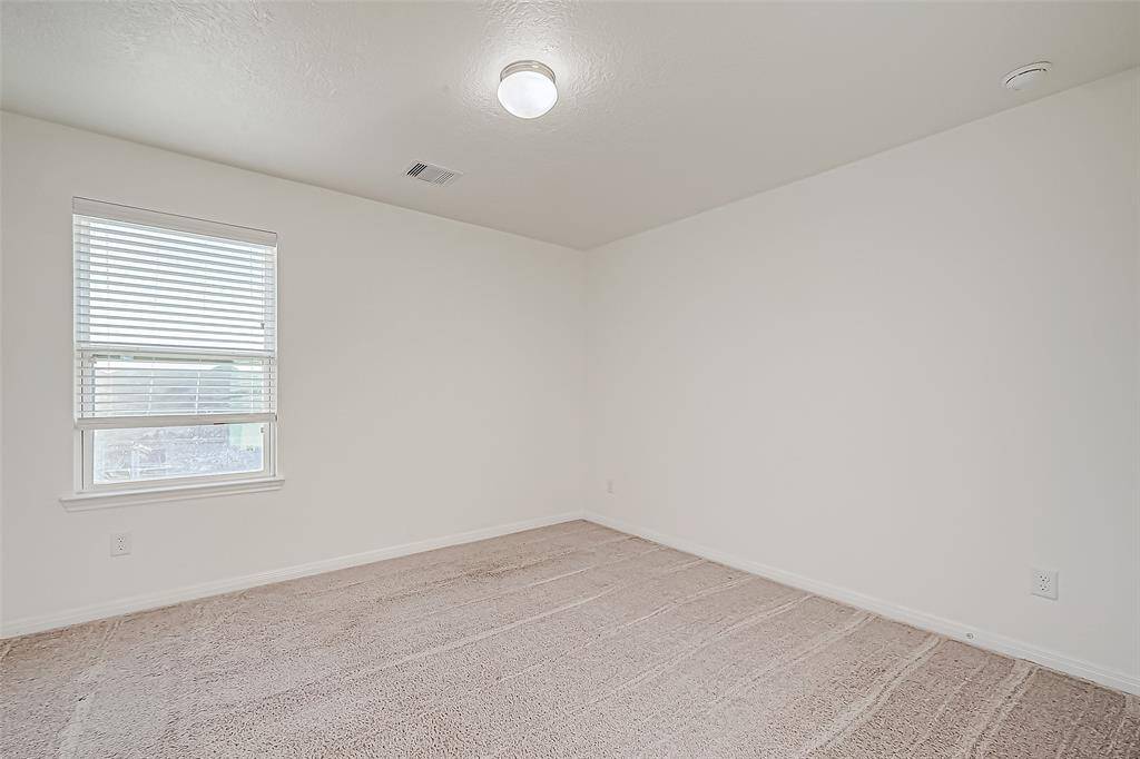 Bright and comfortable, this guest bedroom offers plush carpeting, soothing neutral tones, a spacious closet, and easy access to a nearby full bath, perfect for overnight visitors or everyday use.
