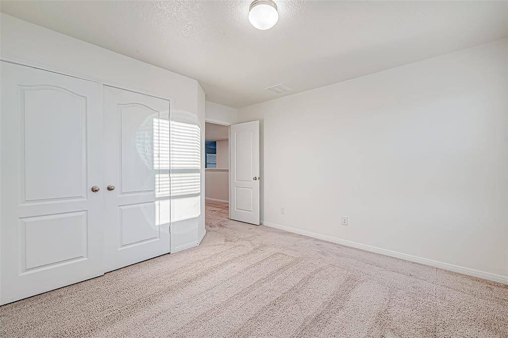 An alternate view of the spacious guest bedroom shows plenty of floor space for furniture, games, toys, and more, plus a large closet.