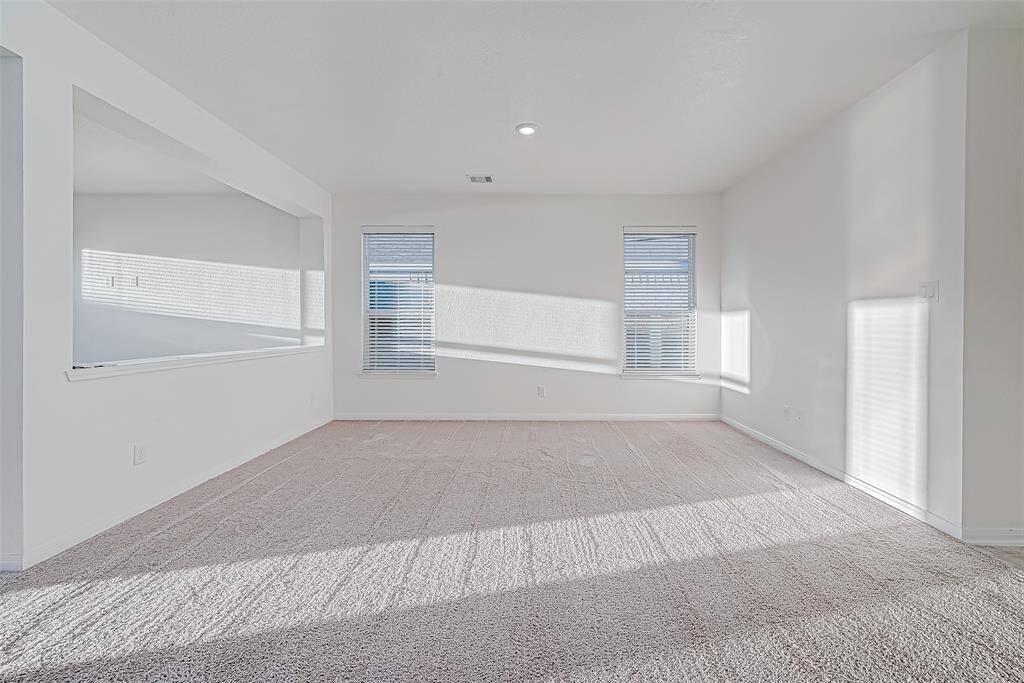 Bathed in sunlight, this versatile front living room offers endless possibilities, whether used as a formal sitting or dining area, or as an extension of the casual living space from the adjoining family room.
