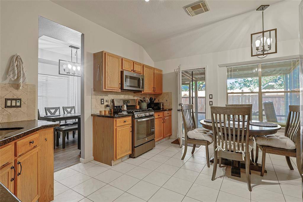 Large eat-in kitchen with granite countertops and all stainless steel appliances including the refrigerator