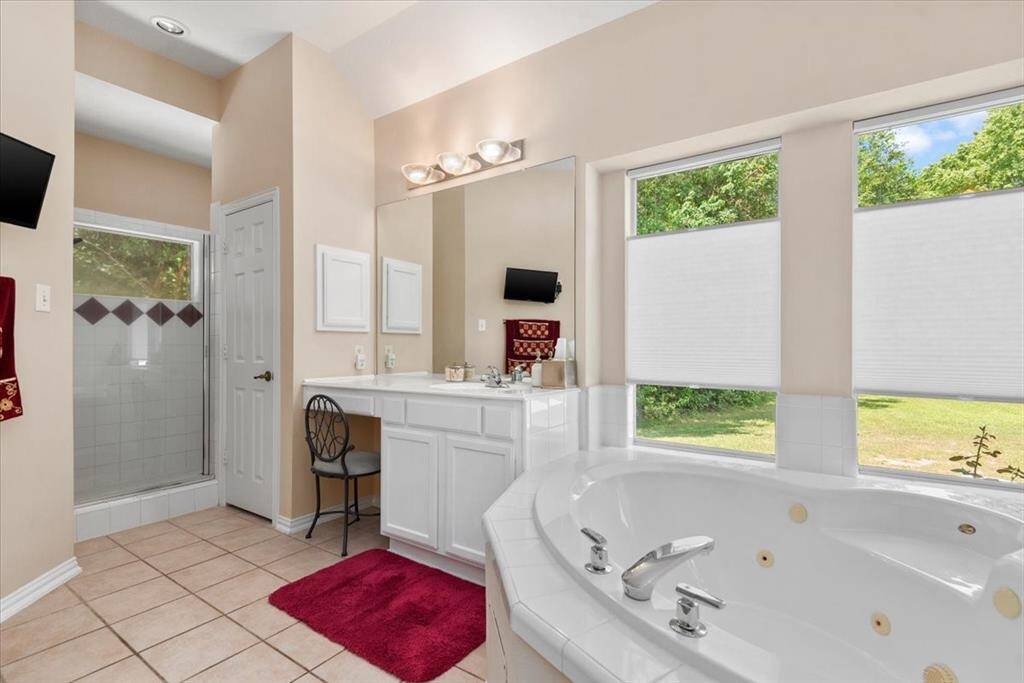 Primary ensuite has  soaking tub w/ jets, separate shower, His and Hers vanities and private water closet.