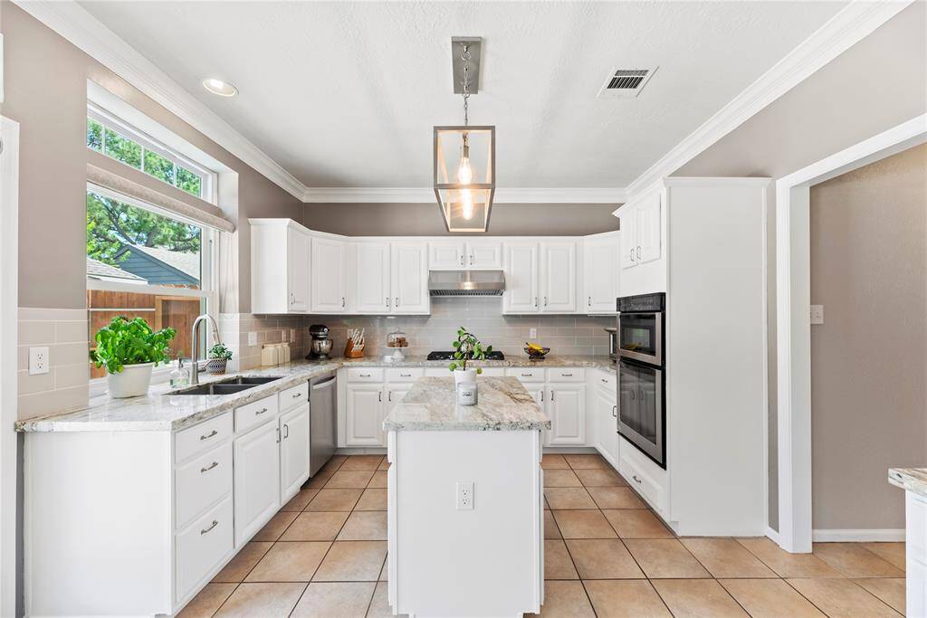 Your chef inspired kitchen awaits! Features include granite countertops paired with a coordinating backsplash, stainless steel appliances, crisp white cabinets with updated hardware, recessed lighting, pendant lighting and a sprawling center island.