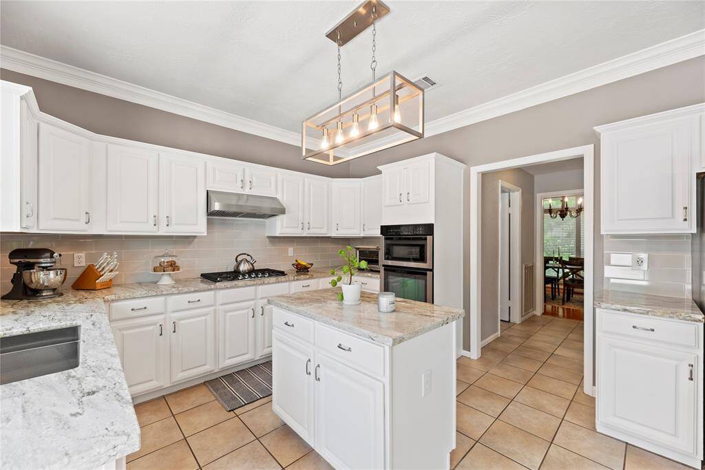 The center island serves as a versatile centerpiece, providing additional workspace and storage.