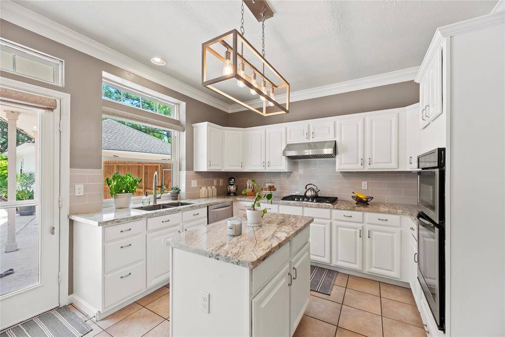 Crisp white cabinets with updated hardware provide a clean and timeless look, enhancing the sense of brightness and openness in this space.