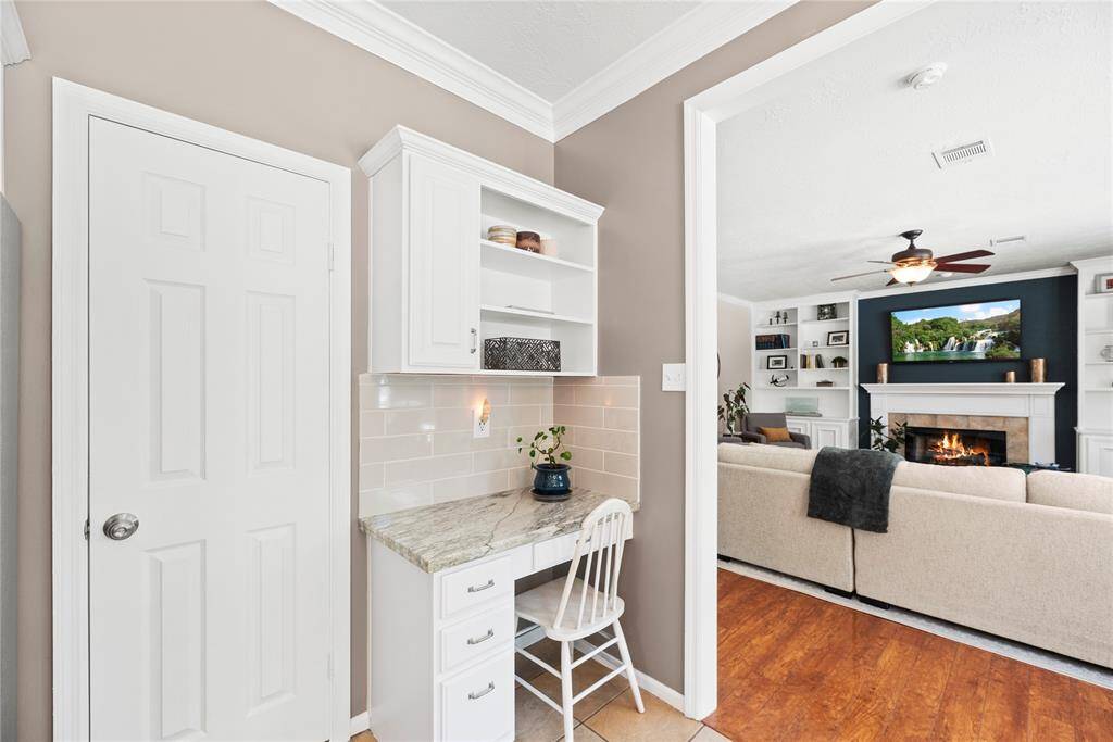 An additional built-in desk area, complete with coordinating countertops and cabinetry, offers the perfect spot for work, study, or staying organized in style.