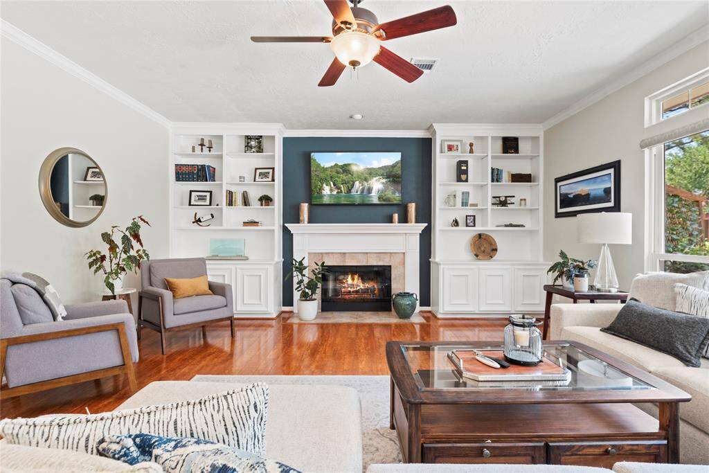 A stylish center fireplace serves as the stunning focal point of the living area, flanked by custom built-in shelves that blend function with refined design.