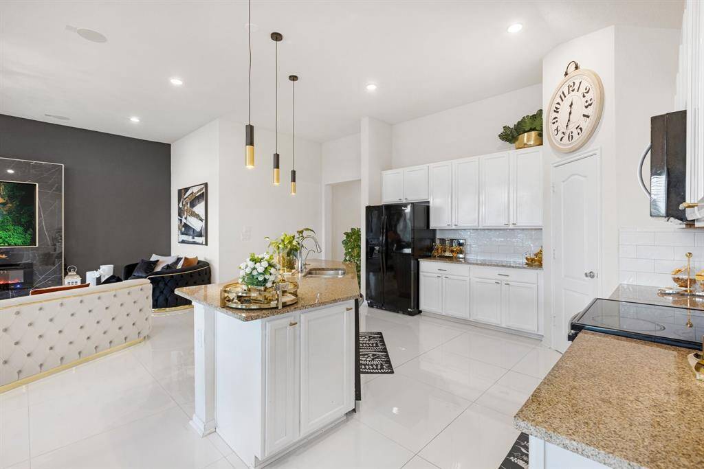 The kitchen features white cabinets,creating a clean and timelessaesthetic.