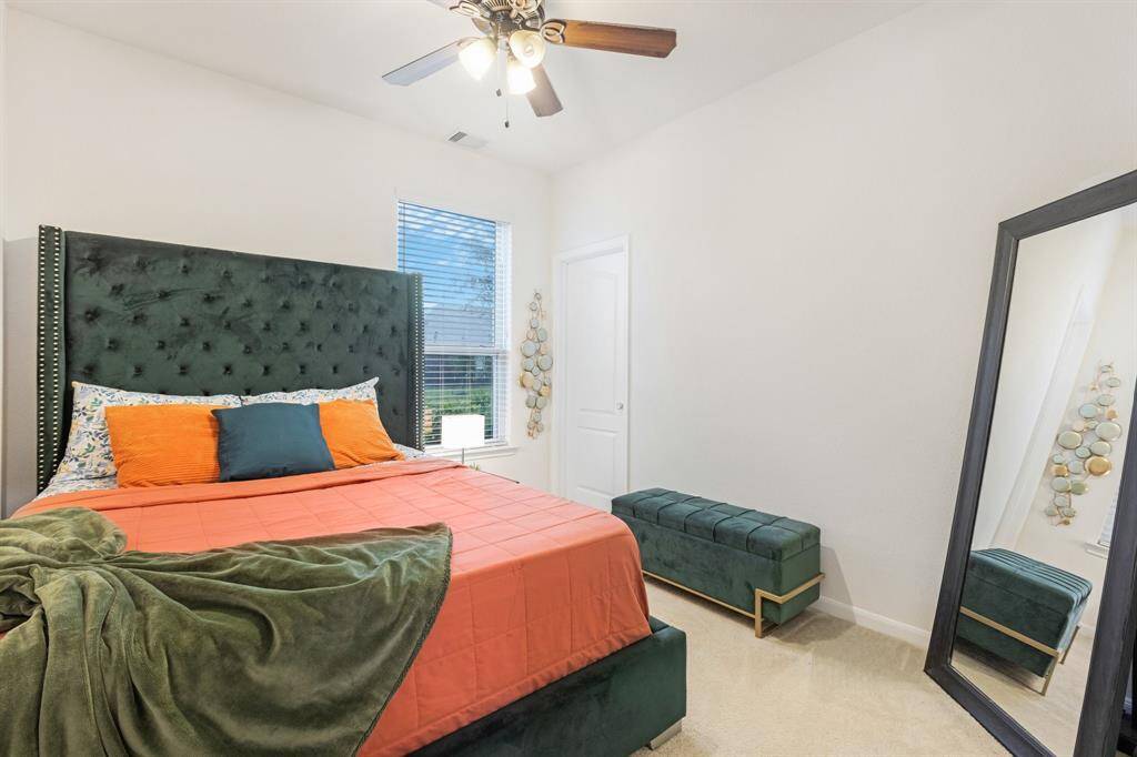 Secondary bedroom features awindow and plush carpet.