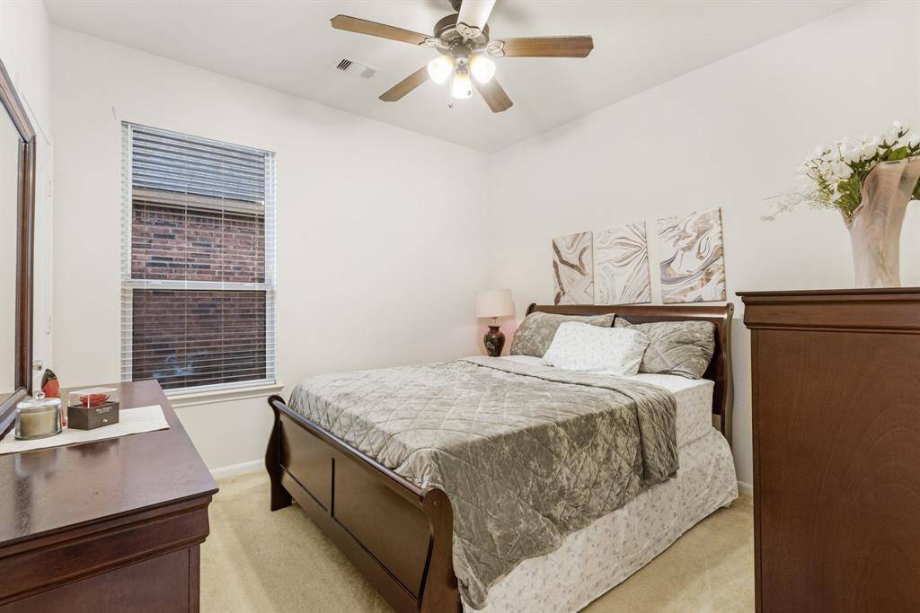 Third bedroom features awindow and plush carpet.