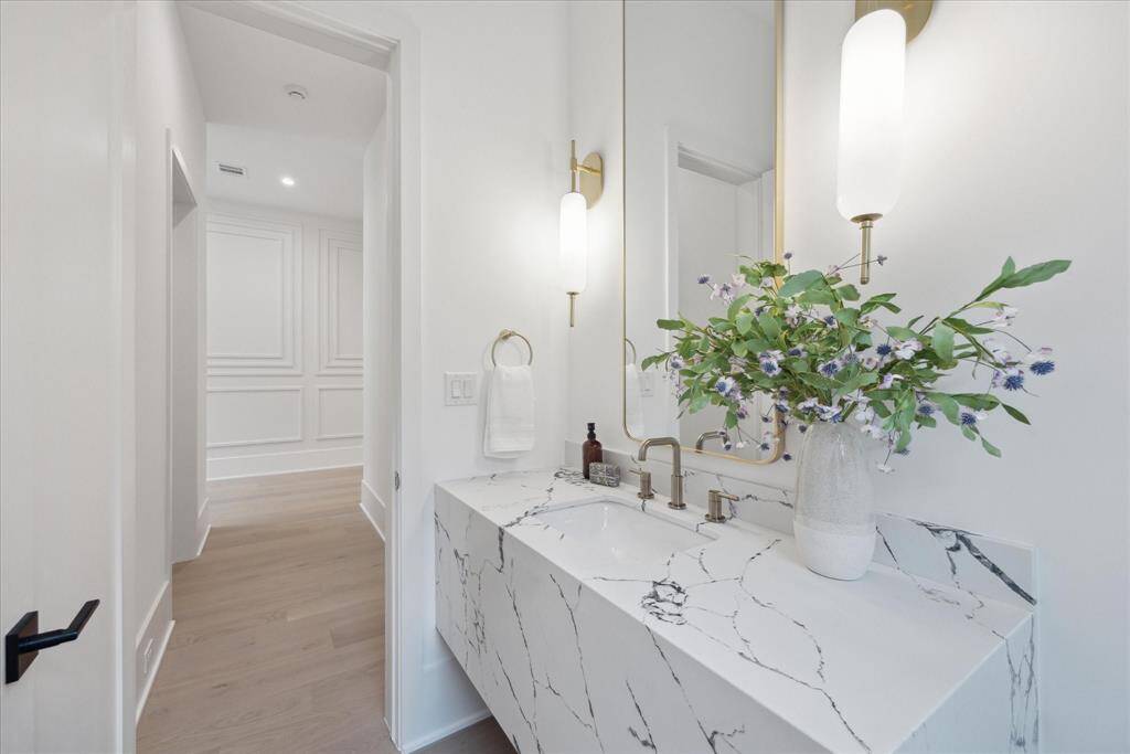 [POWDER ROOM]The first-floor powder room is a tasteful blend of French contemporary elegance and modern convenience, featuring refined fixtures, exquisite finishes, and thoughtfully curated details that create a welcoming space for guests.