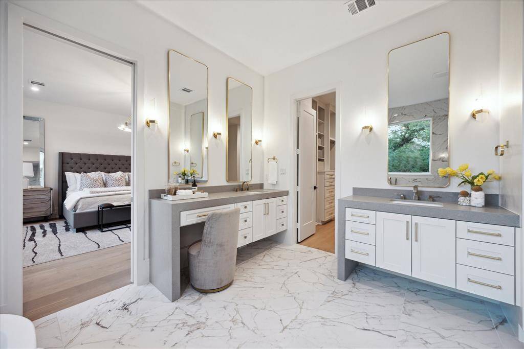 This luxurious space is thoughtfully designed with separate vanities for him and her, each offering generous counter space and custom cabinetry for both functionality and style. A dedicated makeup station adds an extra layer of comfort and convenience, creating a personalized retreat that perfectly balances sophistication and everyday ease. Custom mirrors add a bespoke touch, all coming together to create a serene retreat!