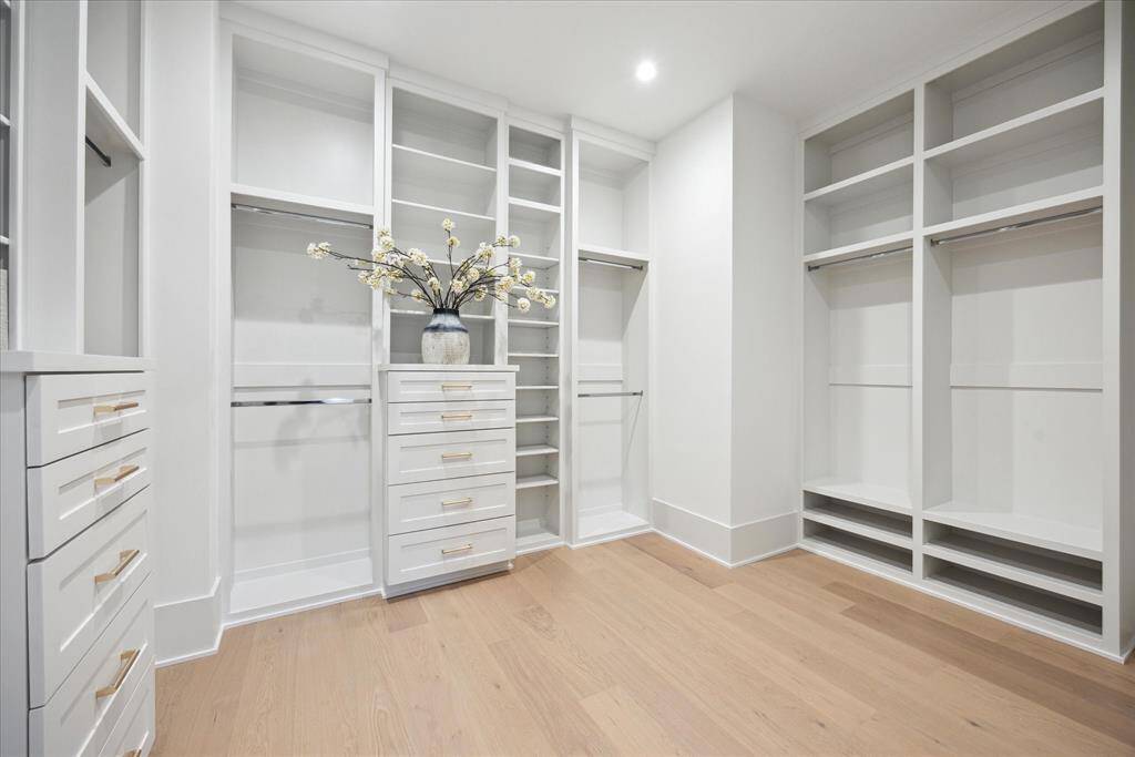 [PRIMARY CLOSET] The spacious, custom-fitted primary closet offers a luxurious dressing experience, thoughtfully designed with tailored shelving, ample hanging space, and built-in storage solutions. This beautifully organized retreat combines function with high-end design.