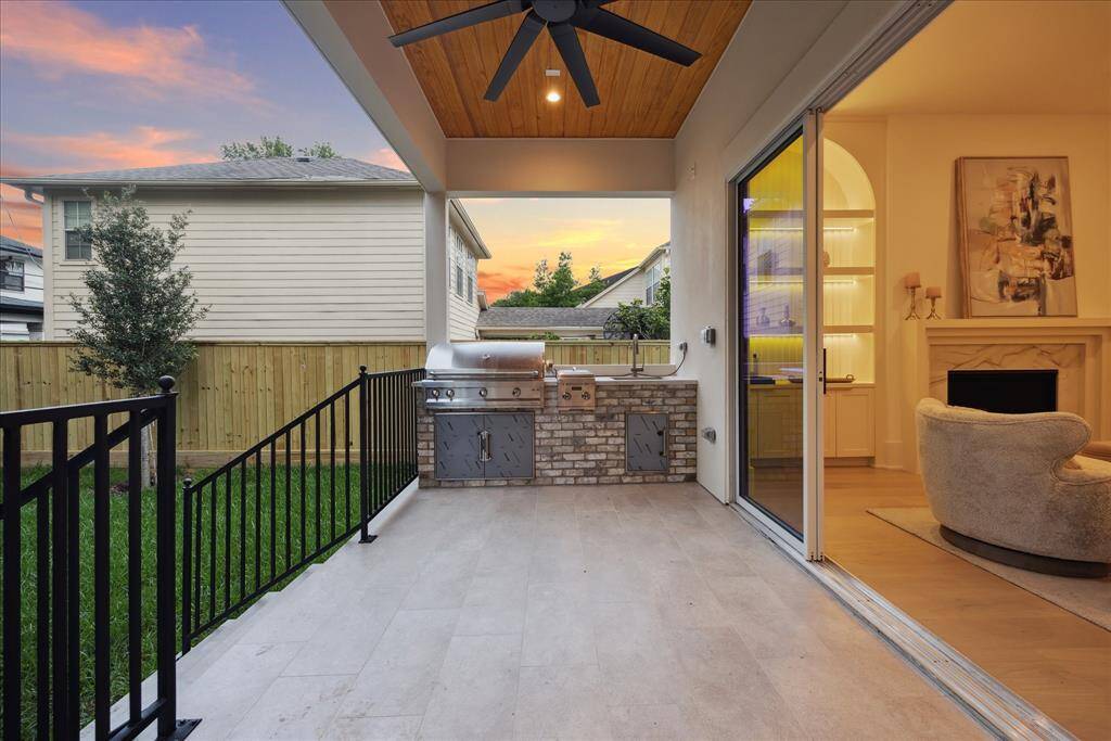 [VERANDA] The covered outdoor veranda is an extension of the home’s contemporary elegance, offering a spacious retreat for year-round enjoyment. Complete with a fully equipped summer kitchen, this stylish outdoor living space is perfect for alfresco dining, entertaining, or simply relaxing while overlooking the surrounding landscape.