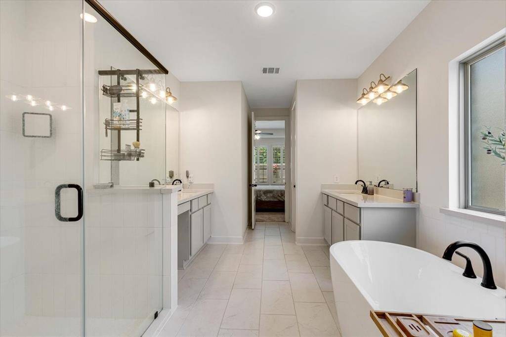 The spa-inspired primary retreat boasts a soaking tub, a standalone shower, and dual vanities!