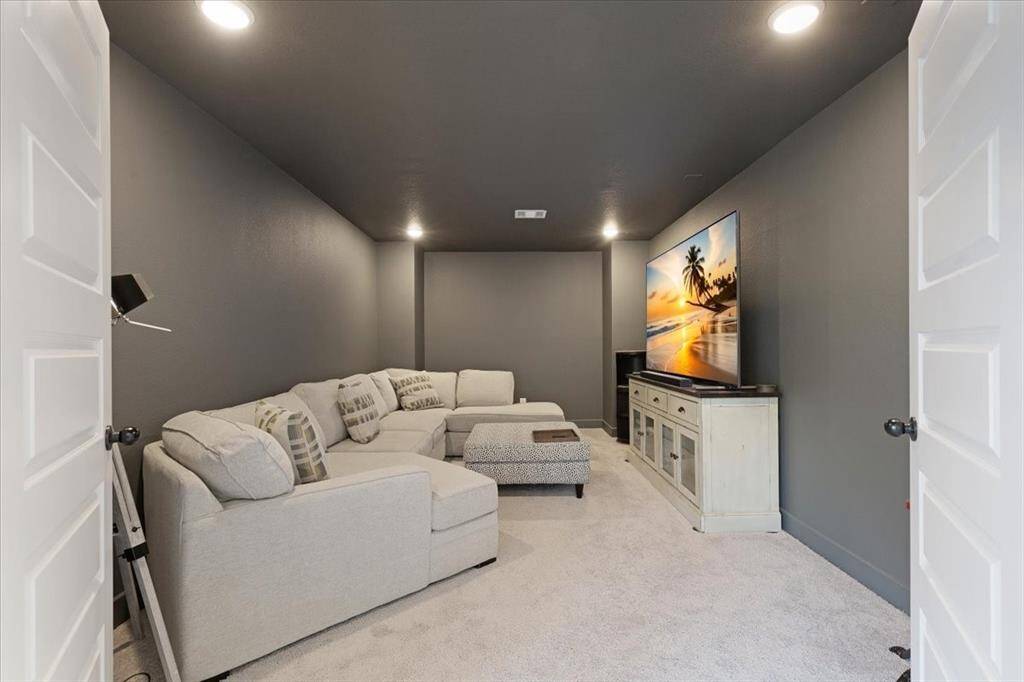 The media room features warm gray walls and is fully wired for surround sound.