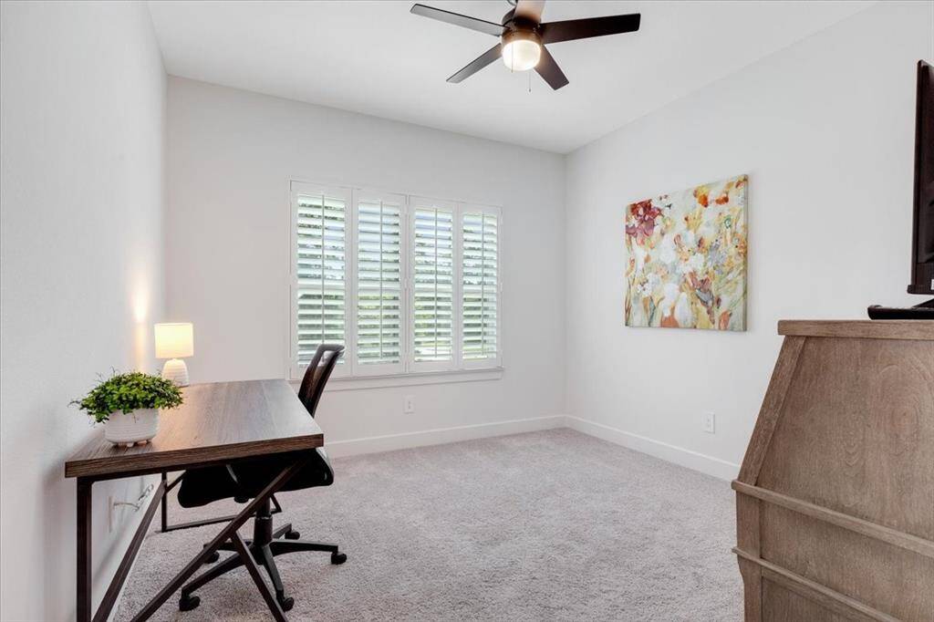 This front-facing guest room features plantation shutters and a spacious walk-in closet with a charming window.