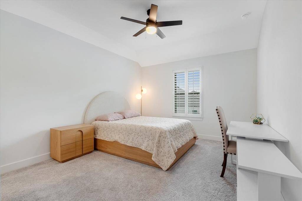 At the top of the stairs, you’ll find another guest bedroom featuring plantation shutters and a full bathroom.