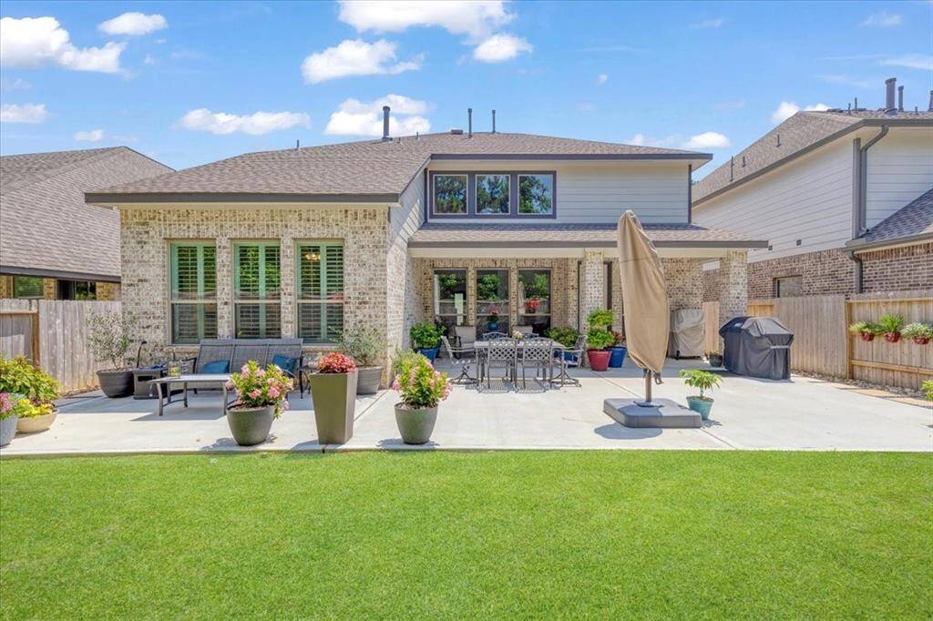 The backyard offers a spacious retreat with a beautifully extended concrete patio—perfect for outdoor dining and relaxation.