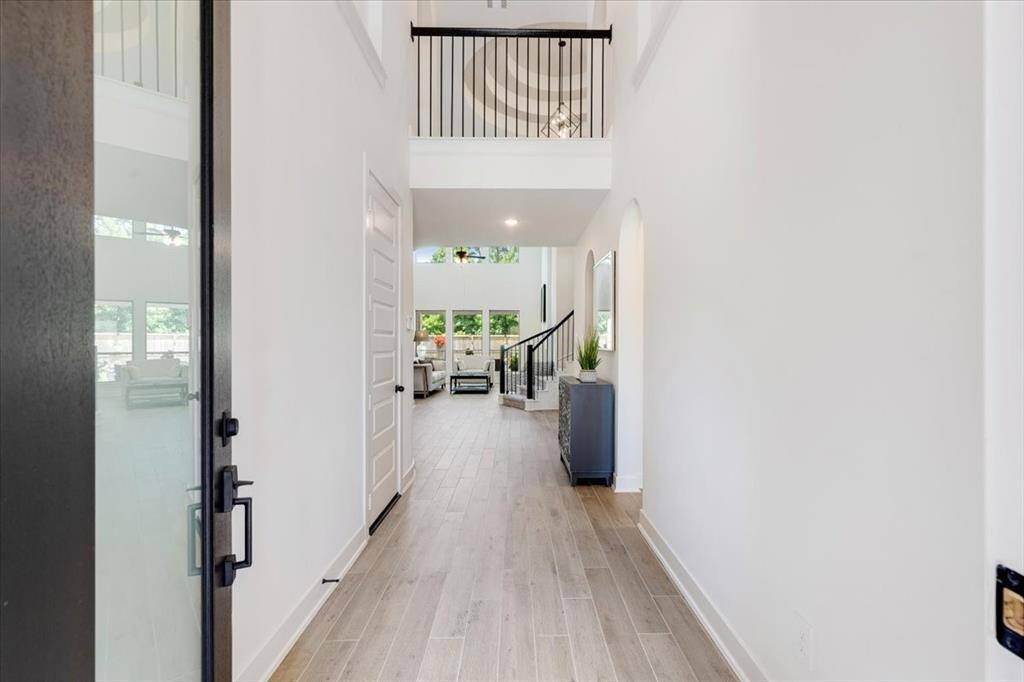 Upon entering, you're welcomed by soaring ceilings and elegant wood-look tile flooring that add a sense of space and style to the home.