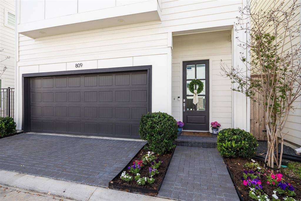 Well maintained landscape leading to front door with pavers on the driveway, walkway and porch.