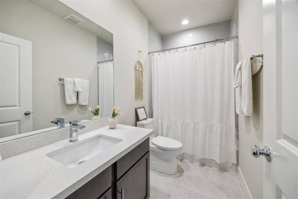 First floor secondary bathroom with large vanity and tub/shower combo