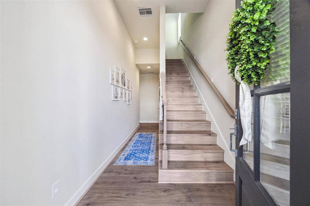 Entry with hallway leading to secondary bedrooms, bath and backyard. Engineered wood throughout including on the stair treads and risers.