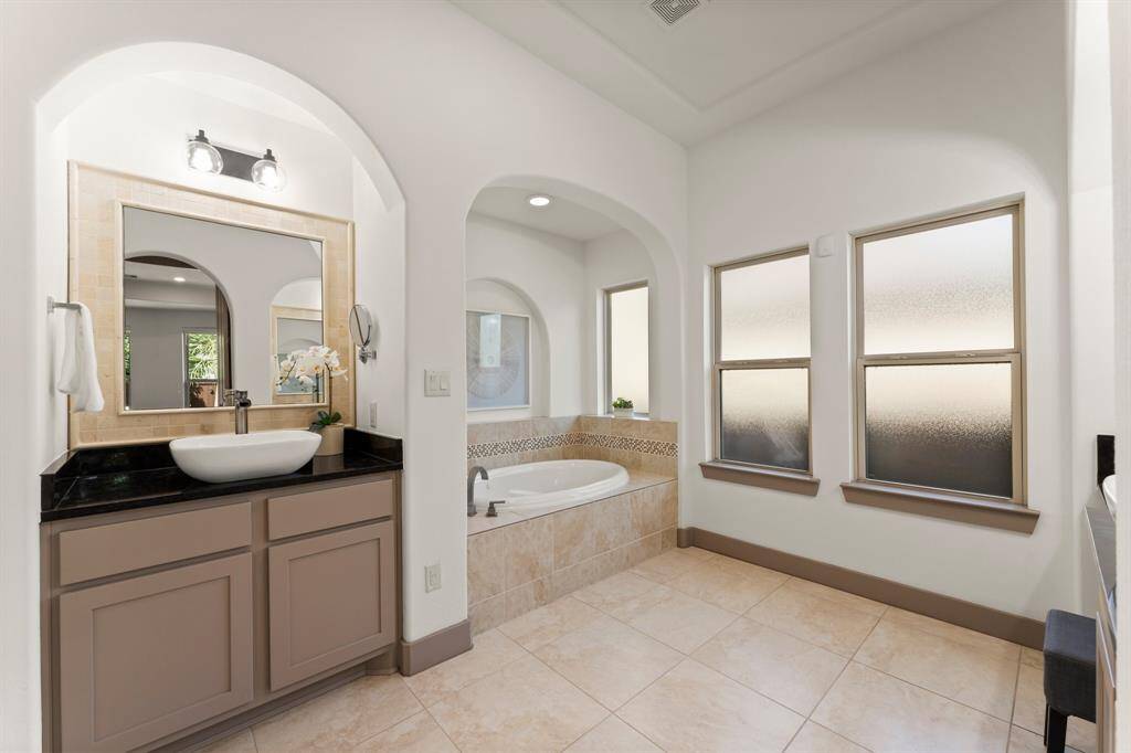 This Spa Like Ensuite Features His and Hers Vanities and Separate Soaking Tub