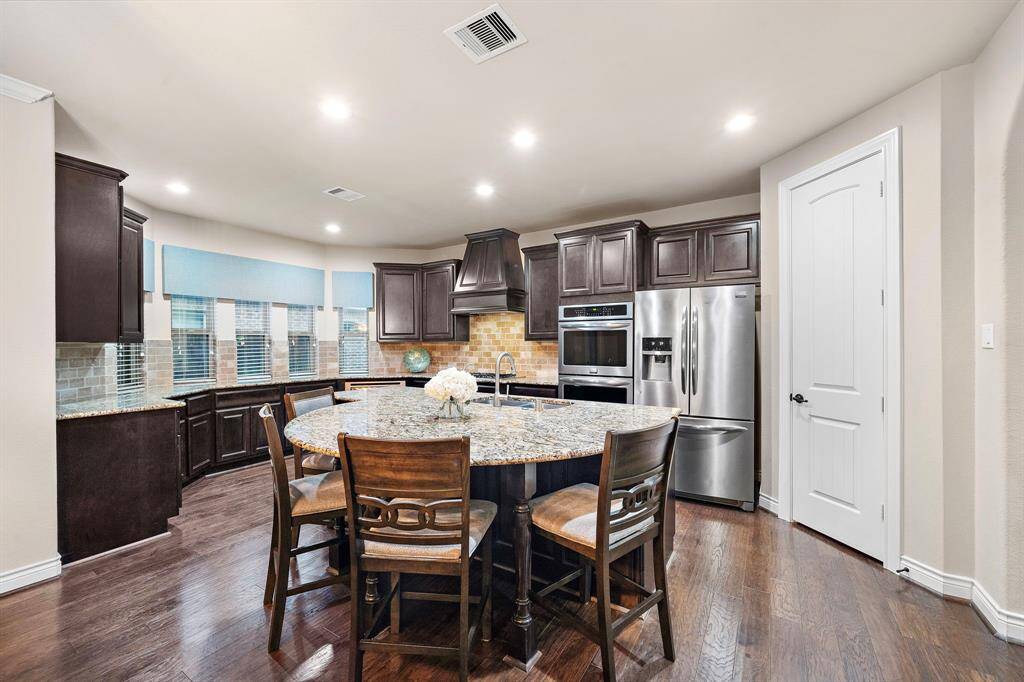 Wrapped in rich cabinetry and topped with sleek granite, the kitchen features stainless steel appliances and under-cabinet lighting that elevate both style and utility.