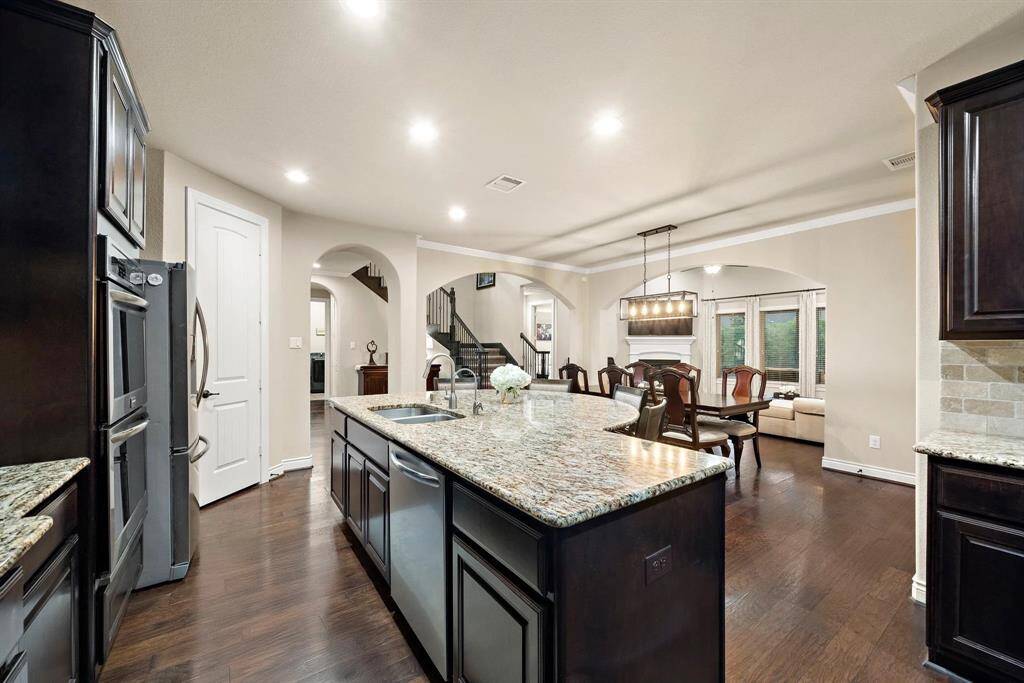 The central island serves as the kitchen’s focal point, complemented by detailed millwork and positioned to provide a gracious connection to the home’s main hall.