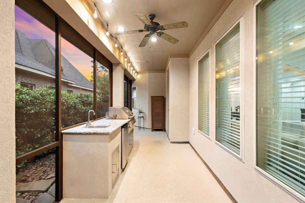 This screened space includes a built-in grill, sink, and prep area, forming an outdoor kitchen designed for effortless hosting within the enclosed patio.