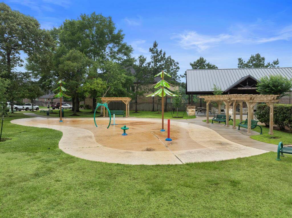 The neighborhood splash pad features interactive water play areas under whimsical shade structures, offering a fun spot for cooling off on warm days. Nearby covered pavilions and shaded seating make it easy to relax while enjoying the vibrant community amenities.