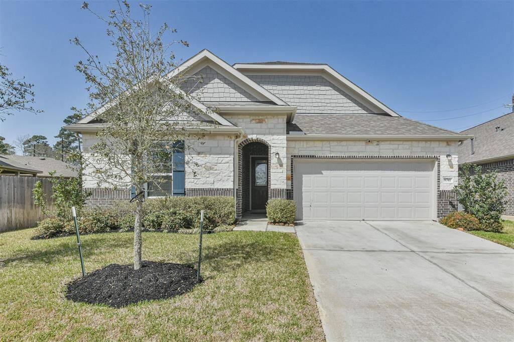 This is a charming single-story home with a brick and stone exterior. It includes a double garage and a welcoming entrance, offering a classic and inviting curb appeal.