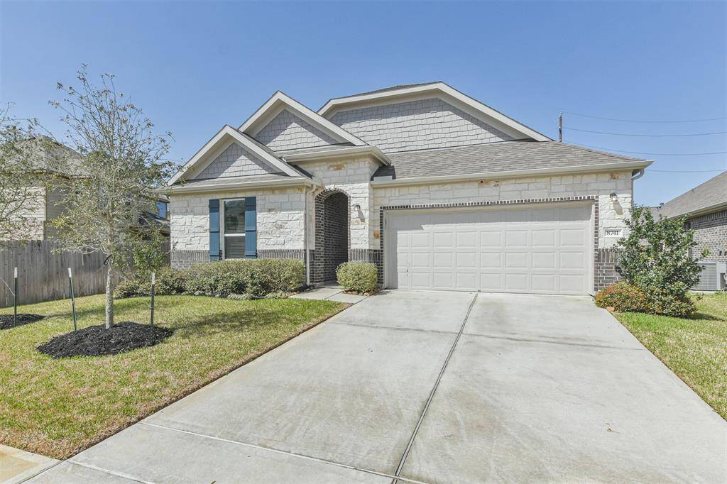 This is a charming single-story home with a brick and stone exterior ,that features a two-car garage and a well-maintained front yard. The driveway is spacious, and the entryway is inviting with a slight arch.
