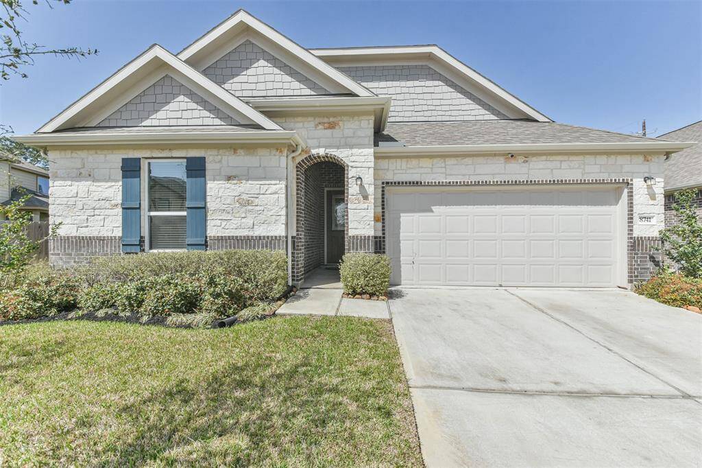 Gabled roof, and blue shutters. It includes a two-car garage and a well-maintained front yard.