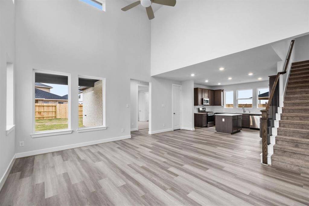 Experience the spacious elegance of this living room, featuring soaring ceilings and an open design bathed in abundant natural light for a serene, expansive feel.
