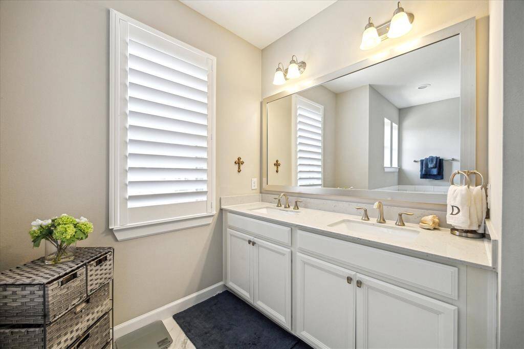 A spacious double vanity with quartz countertops and framed mirror offers both beauty and function—perfect for starting and ending your day in style.