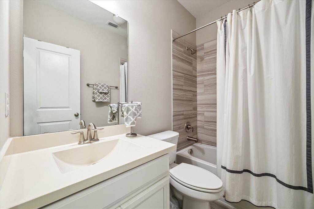 This full secondary bathroom on the second floor features a sleek vanity, brushed nickel fixtures, and a stylish tub/shower combo with modern tile surround—perfect for guests or family use.