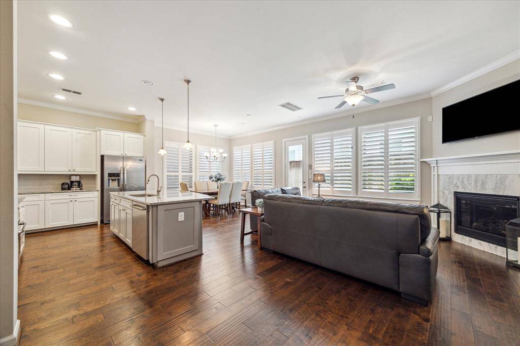 A seamless blend of kitchen, dining, and living spaces creates an effortless flow—perfect for entertaining or everyday comfort, all framed by rich hardwoods and timeless finishes.