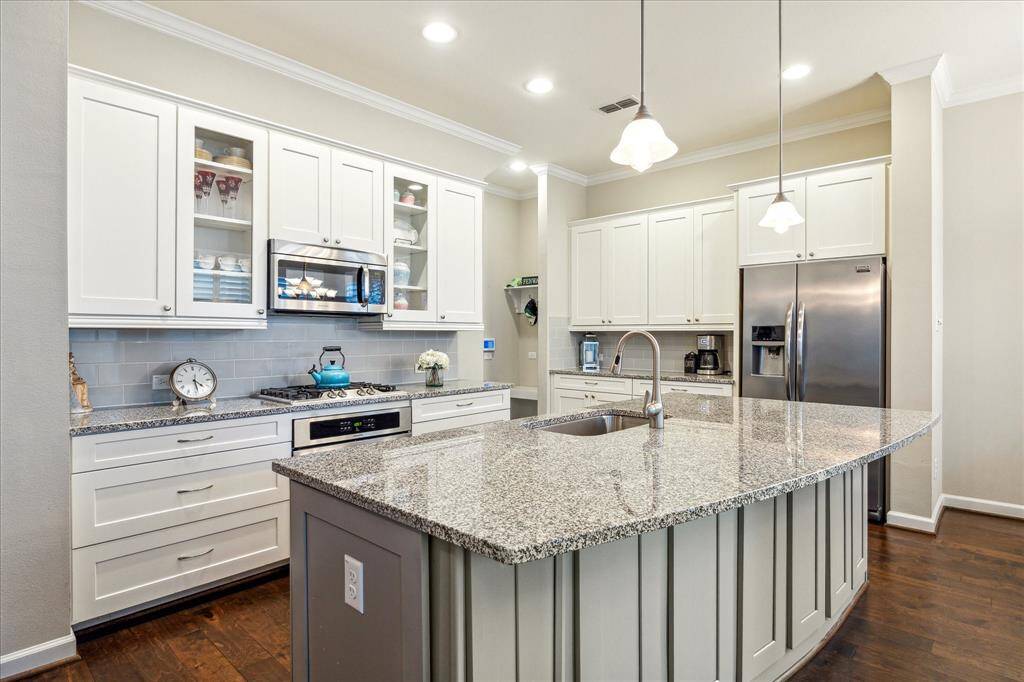 A closer look at the kitchen’s heart—showcasing glass-front cabinetry, a gas cooktop, and generous prep space for every cooking need.