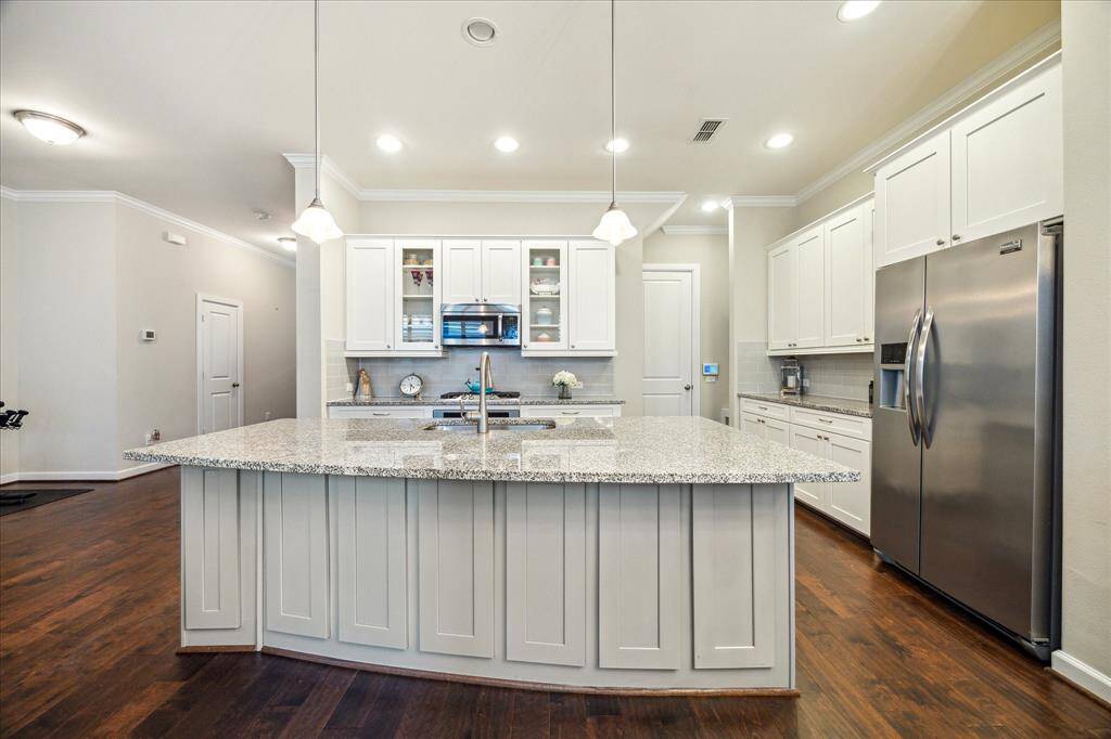 The oversized island steals the spotlight, offering bar seating, ample storage, and a perfect spot to gather while entertaining or prepping meals.