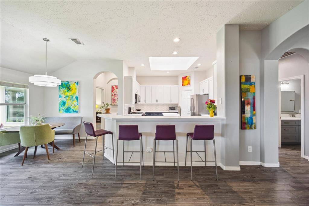 The open-concept kitchen features Energy Star appliances, bar seating, and a bright skylight overhead.