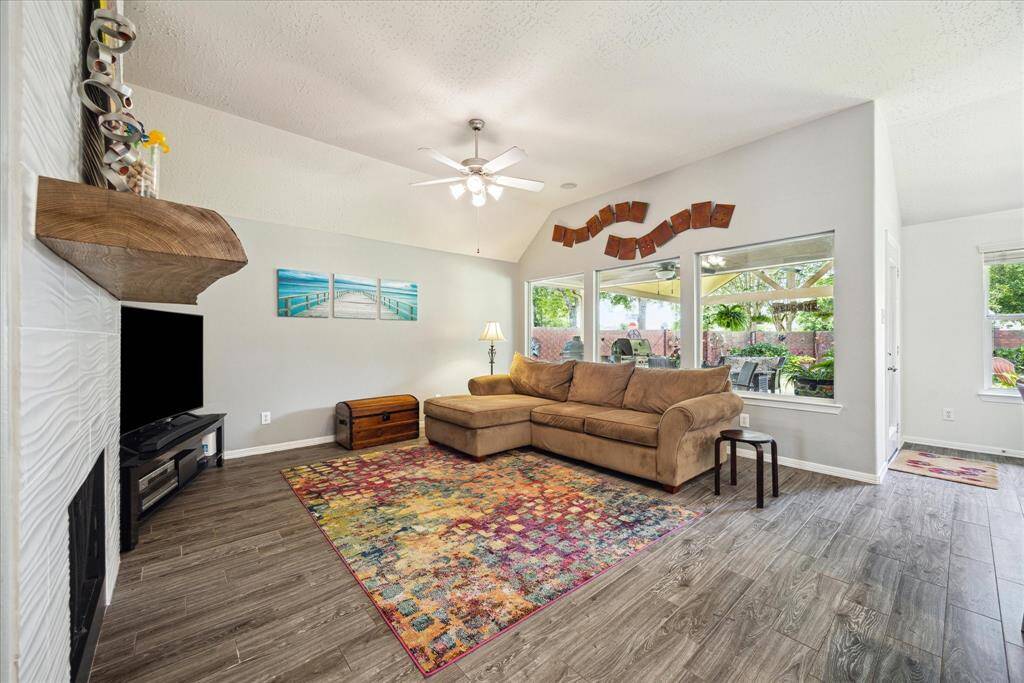 The spacious family room is anchored by a stunning floor-to-ceiling fireplace with a custom floating wood mantel.