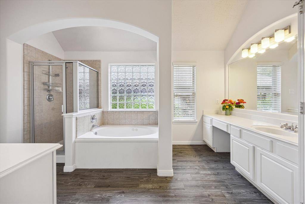 Indulge in the ensuite bath with a jetted soaking tub, separate shower, dual vanities, and abundant natural light.