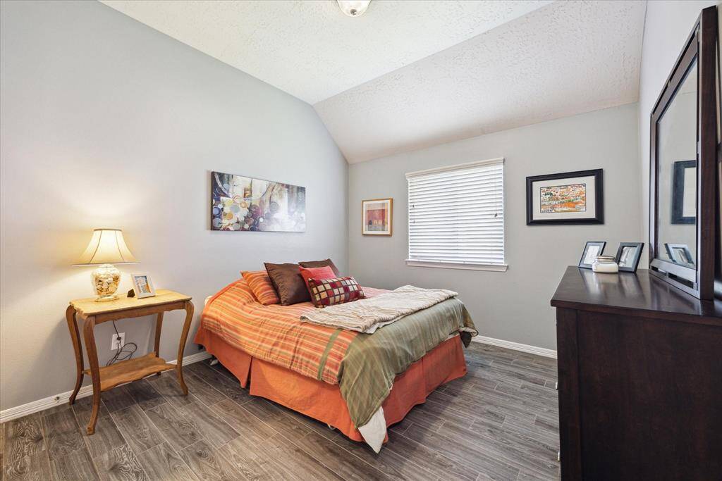 One of two secondary bedrooms, offering generous space, soft wall tones, and a large window for natural light.