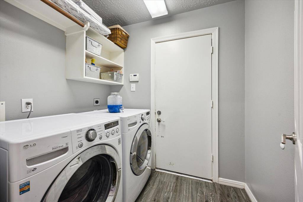 A functional laundry room with built-in storage offers everyday convenience, and the washer and dryer will stay with the home.