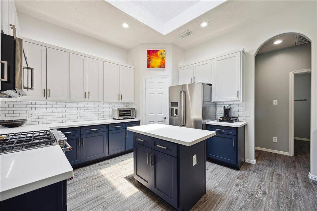 The remodeled kitchen features two-tone cabinetry, subway tile backsplash, and a suite of KitchenAid Energy Star appliances.