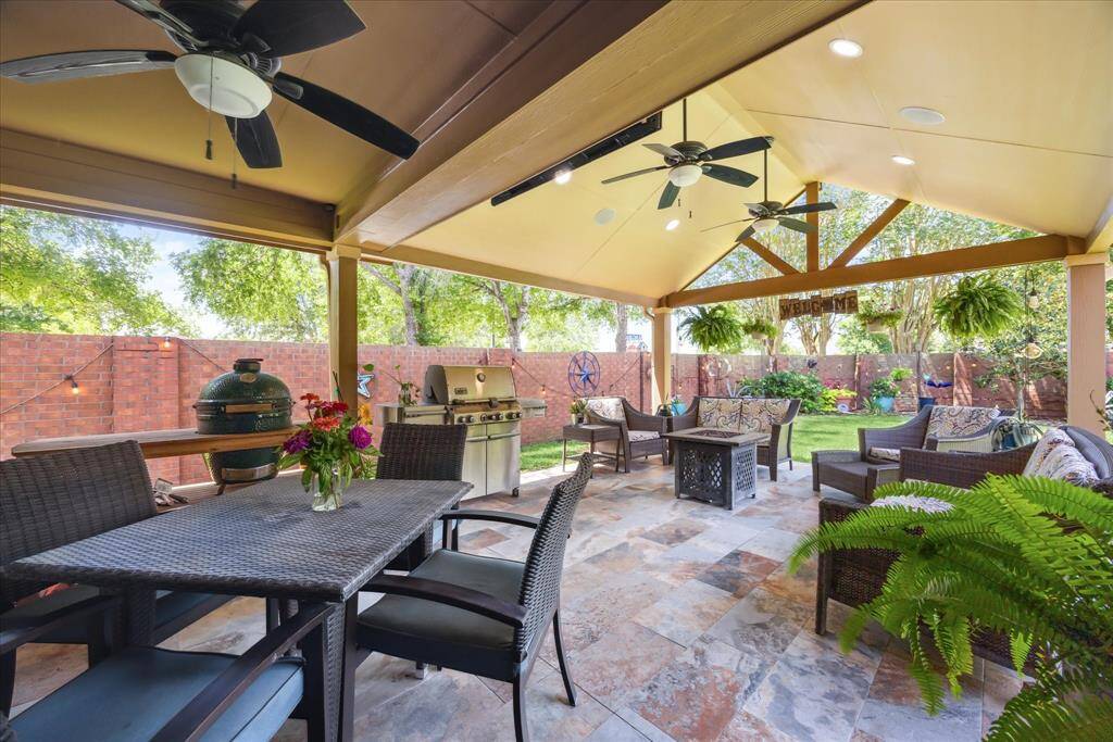 The expansive covered patio with ceiling fans, tile flooring, and plenty of space for dining and lounging is perfect for outdoor entertaining.